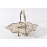 Good quality Edwardian silver cake basket of oval form with faceted and pierced decoration and swing