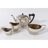 George V silver four piece tea set, comprising teapot of half fluted form, with angular ebony handle