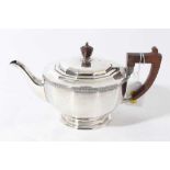 George V silver teapot of cauldron form with faceted decoration, bakelite finial and angular handle