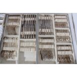 Extensive part canteen of silver cutlery with decorative scroll borders and engraved initials, compr