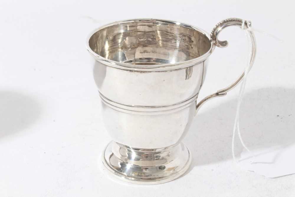 George V silver christening mug of tapered form with central reeded band, with scroll handle, on a c - Image 6 of 11