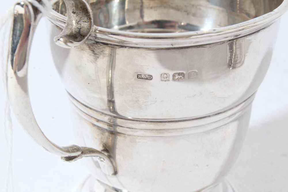 George V silver christening mug of tapered form with central reeded band, with scroll handle, on a c - Image 8 of 11