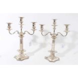 Pair of George VI silver candelabra, each with fluted columns and gadrooned borders, removable twin