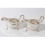 Pair of Edwardian silver sauce boats of conventional form with scroll handles, each raised on three