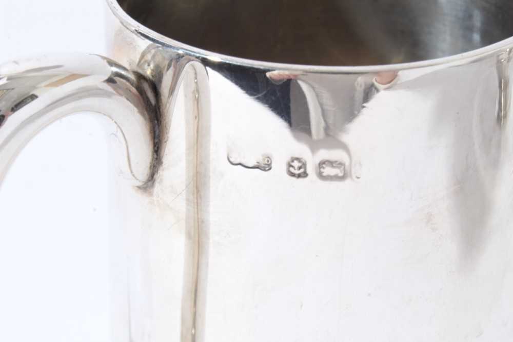 George V silver christening mug of tapered form with central reeded band, with scroll handle, on a c - Image 5 of 11