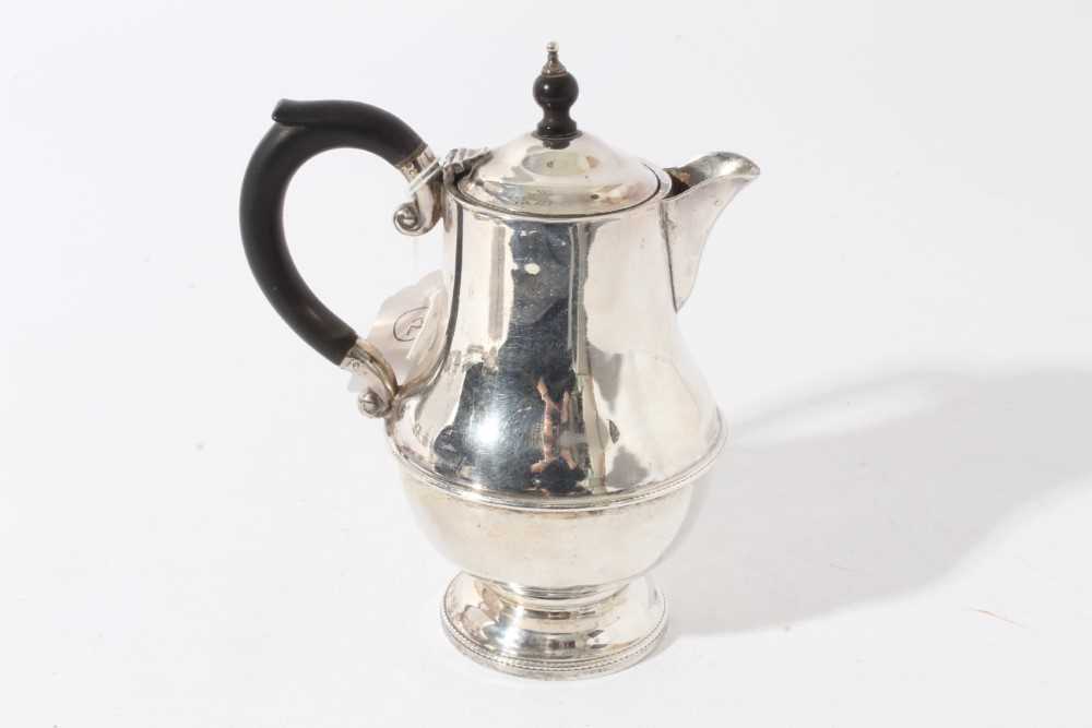 George V silver hot water pot of baluster form with ebony finial and loop handle (Birmingham 1931),