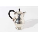 George V silver hot water pot of baluster form with ebony finial and loop handle (Birmingham 1931),