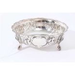 Victorian silver sugar bowl of circular form with foliate embossed borders, on three scroll feet ( L