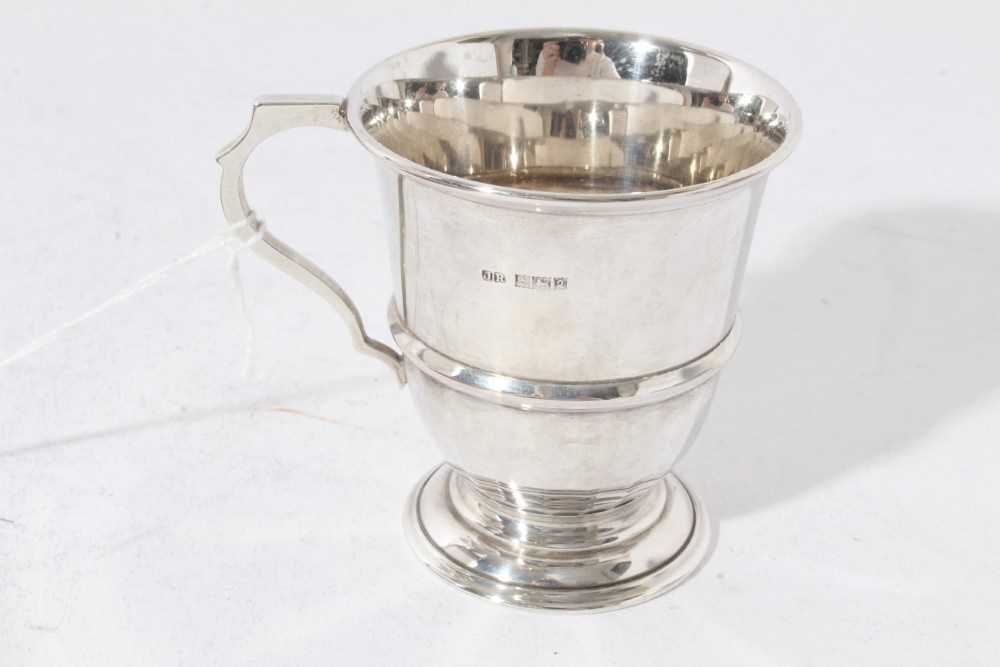 George V silver christening mug of tapered form with central reeded band, with scroll handle, on a c - Image 10 of 11