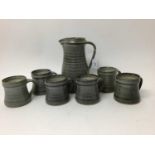 St Ives studio pottery jug, 22cm high, and six St Ives pottery mugs, 9cm high