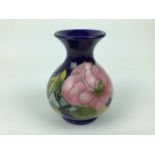 Moorcroft pottery vase decorated in the Magnolia pattern on blue ground, impressed marks to base, 13