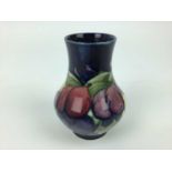 Moorcroft pottery vase decorated in the Wisteria pattern on blue ground, impressed marks and blue pa