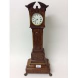 Edwardian miniature longcase clock in mahogany case with brass lion paw feet, with white enamel dial