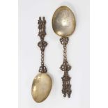 Pair ornate 19th century Dutch silver gilt serving spoons with cast figure terminals and dolfin deco