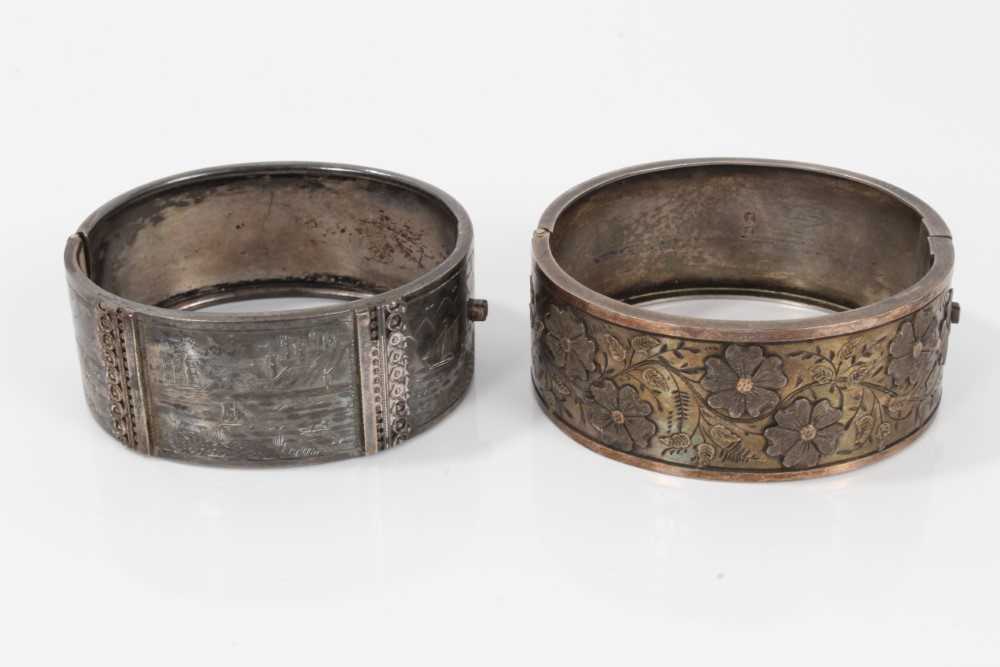 Two Victorian silver hinged bangles, one with applied and textured floral design, Birmingham 1883, t