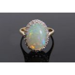 Opal and diamond cluster ring with an oval cabochon opal surrounded by 20 single cut diamonds on 18c