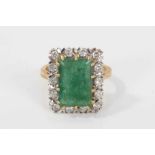 Emerald and diamond cluster ring with a rectangular step cut emerald measuring approximately 12.85mm