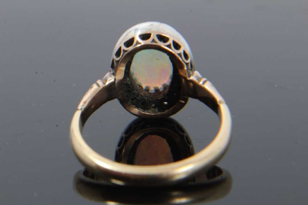 Antique opal and diamond cluster ring with an oval cabochon opal surrounded by nineteen old cut diam - Image 2 of 9