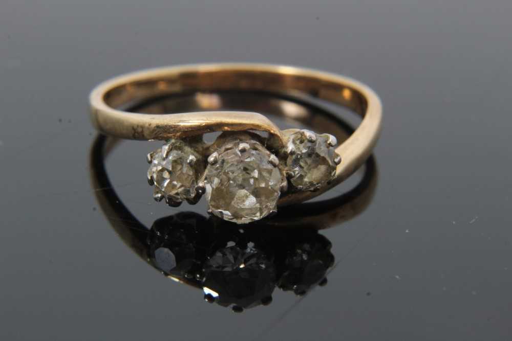 Diamond three stone ring with three old cut diamonds in cross-over claw setting on 9ct gold shank. E