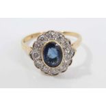 Sapphire and diamond cluster ring with an oval mixed cut blue sapphire measuring approximately 7.75m