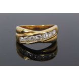 Diamond ring with two cross-over bands and a row of seven channel set brilliant cut diamonds estimat