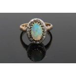 Antique opal and diamond cluster ring with an oval cabochon opal surrounded by nineteen old cut diam