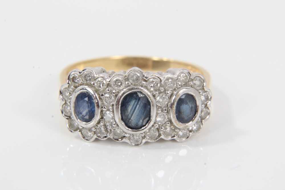 Sapphire and diamond triple cluster ring with three oval mixed cut blue sapphires surrounded by bril