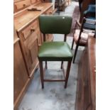 Set of four bar stools with green upholstered seats and backs
