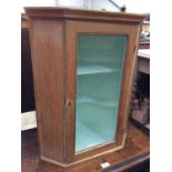Antique pine hanging corner cupboard with painted interior enclosed by glazed door