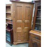 Pine corner cupboard with shelved interior enclosed by four panelled doors, 99cm wide, 201cm high