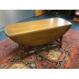 Ercol elm dropleaf coffee table on turned supports joined by stretchers 107 cm