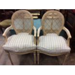 Pair of painted open armchairs with caned backs and loose cushions in Bernard Thorp fabric, together