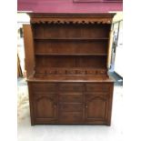Good quality reproduction dresser with plate rack above an assortment of draws and cupboards