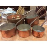 Group of graduated copper pans together with two stoneware bottles