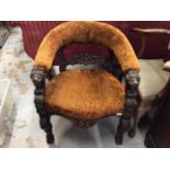 Victorian carved oak framed tub chair with golden brown upholstery and carved grotesque mask termina