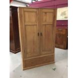Antique pine wardrobe enclosed by two doors with drawer below