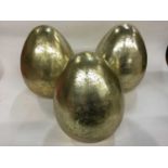Three large decorative glass golden eggs
