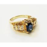 A marked 14k yellow metal ring, set with central oblong synthetic sapphire and six small diamonds