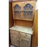 A 36" modern pine two part dresser with leaded effect glazed panel doors to top over a stripped base