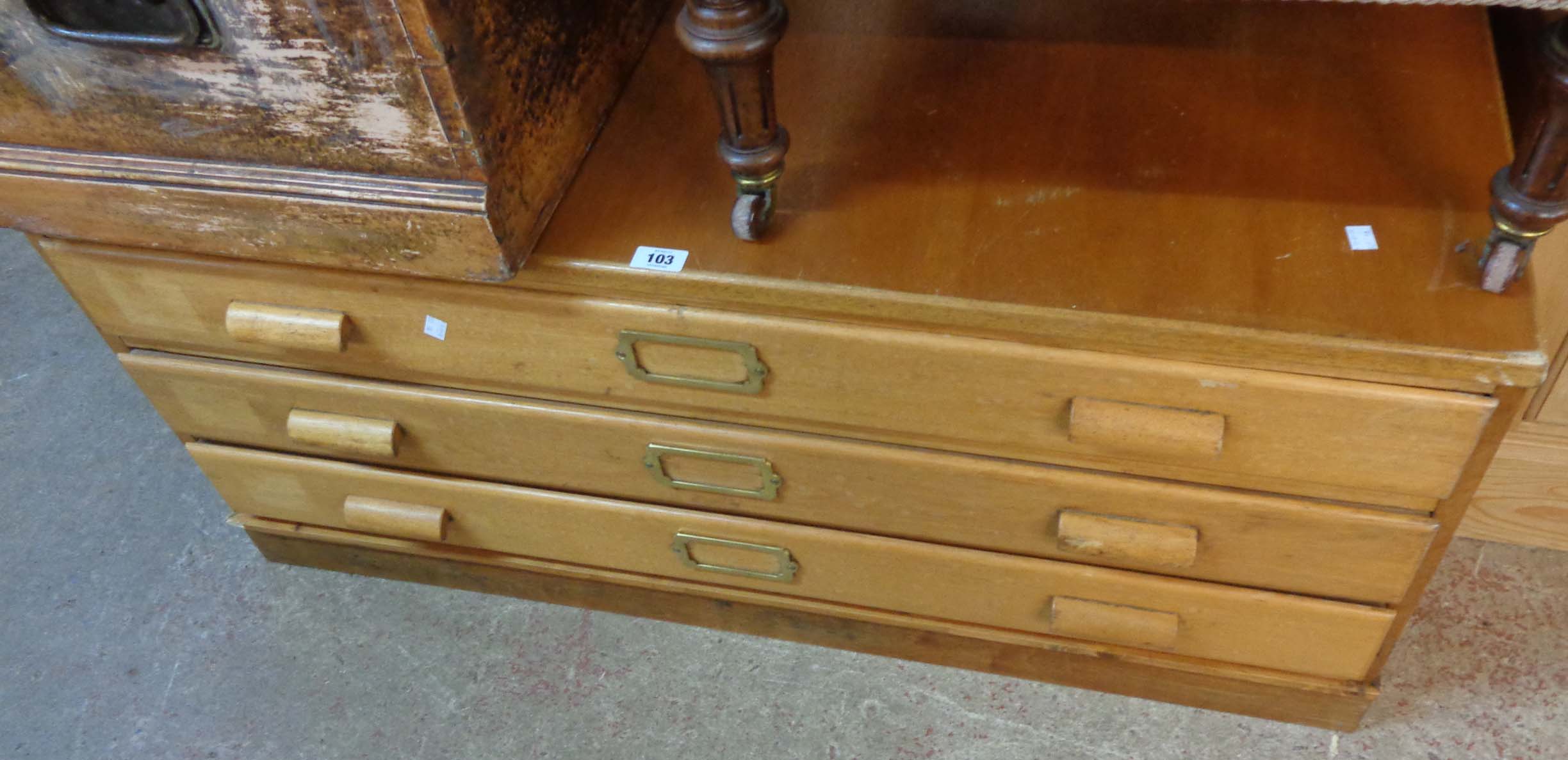 A 3' 9" 20th Century mixed wood plan chest of three long drawers with brass title frames, set on