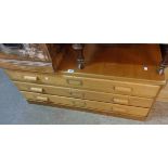 A 3' 9" 20th Century mixed wood plan chest of three long drawers with brass title frames, set on
