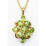 A hallmarked 375 gold peridot encrusted pendant on a marked 375 neck chain