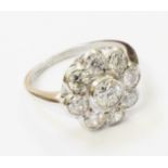 A marked PLAT 1920`s style flowerhead ring, set with central brilliant cut diamond within an eight