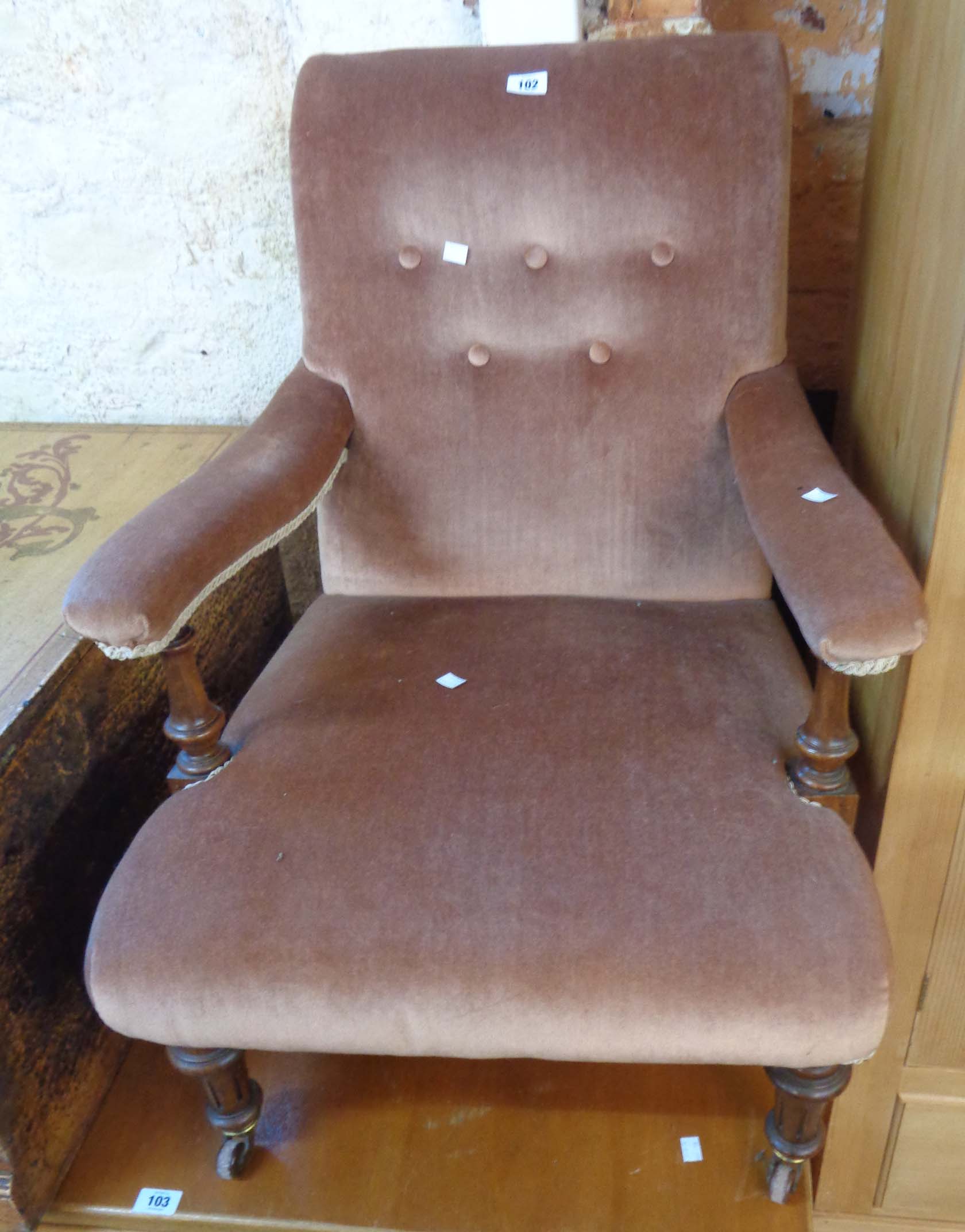 A late 19th Century walnut framed open armchair upholstered in button back old rose velour, set on