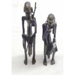 A pair of 20th Century African cast bronze figures, depicting a seated man and woman, holding