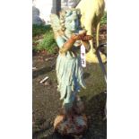 A painted cast iron garden fairy stood holding a bird