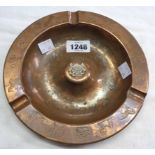 A copper dish with the coat of arms for Botswana with wildlife motifs engraved on the rim
