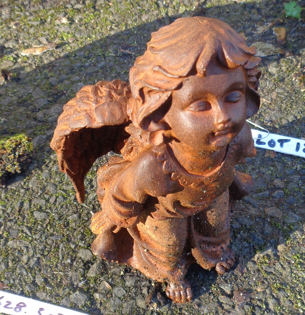 A cast iron garden angel with rusted finish