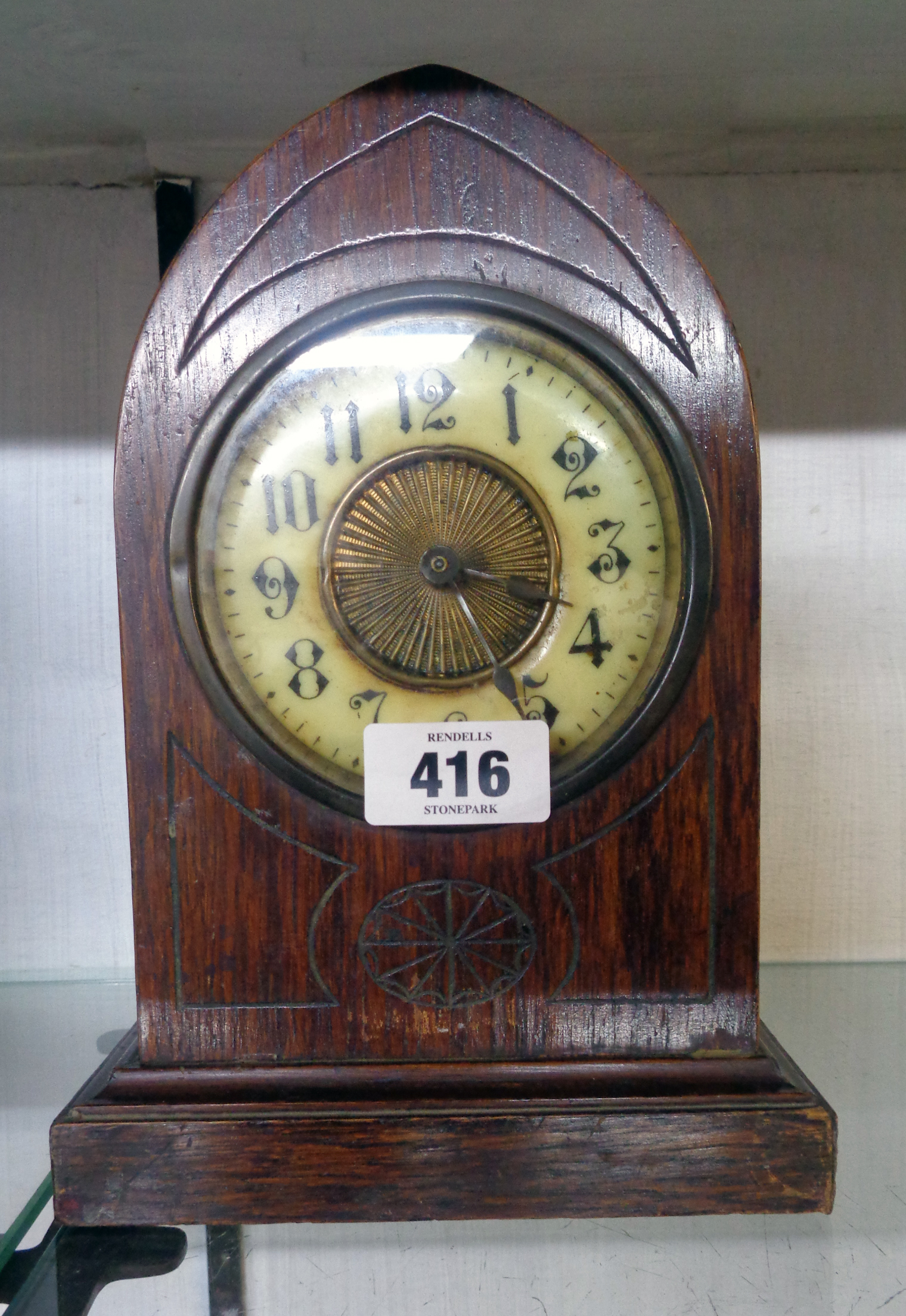 An early 20th Century polished oak mitre shaped cased mantel alarm clock with American bell striking