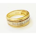 An import marked 750 gold ring, set with a row of ten small princess cut diamonds